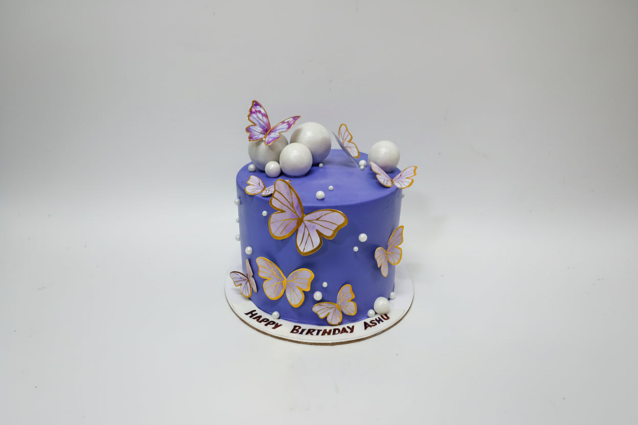 Blue birthday cake with butterfly decorations on a white background