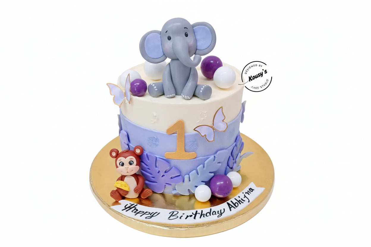 Birthday cake with elephant and monkey decorations on a white background