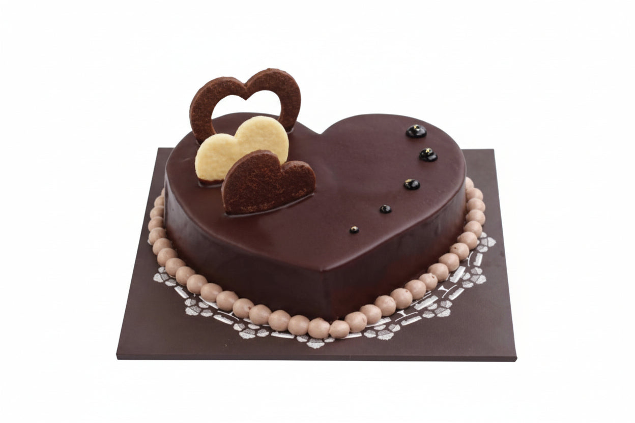 Heart-shaped chocolate cake with decorative elements on a white background