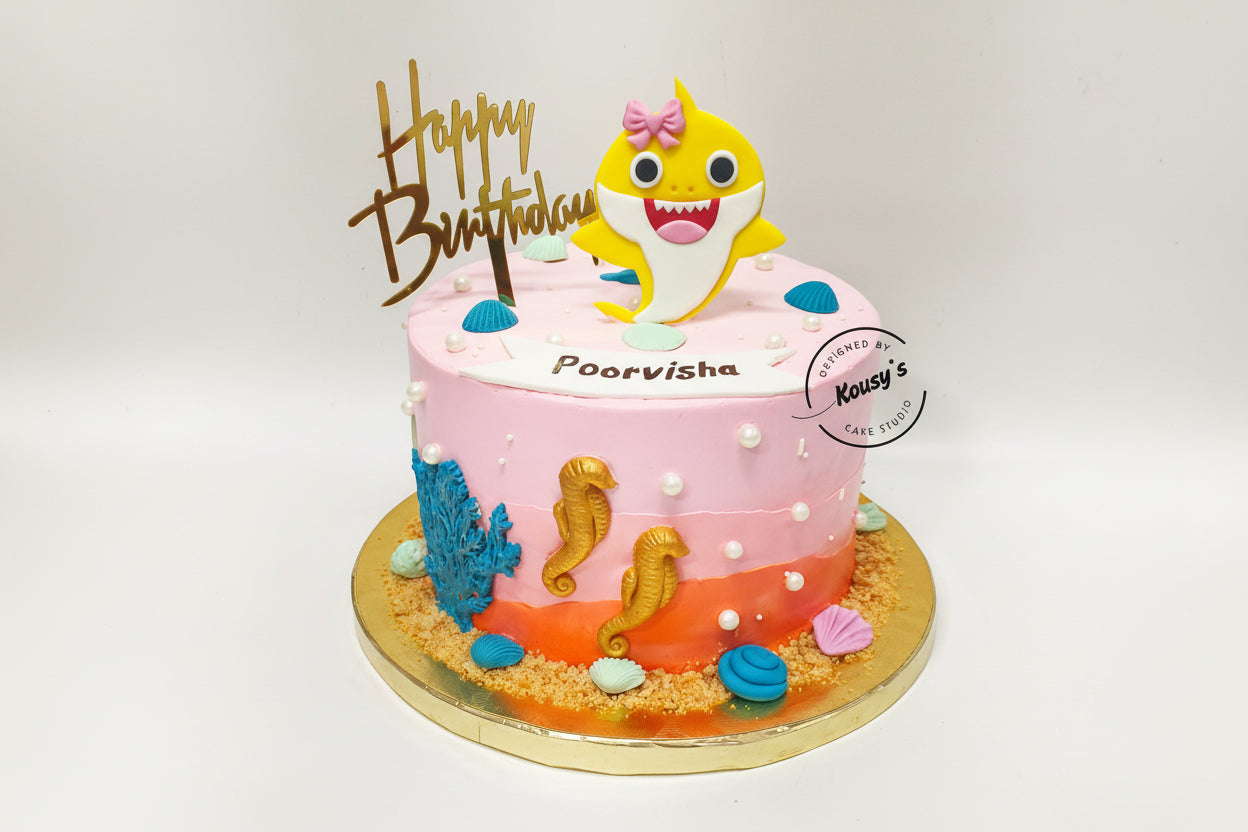 Birthday cake with a shark character and 'Happy Birthday' topper on a white background