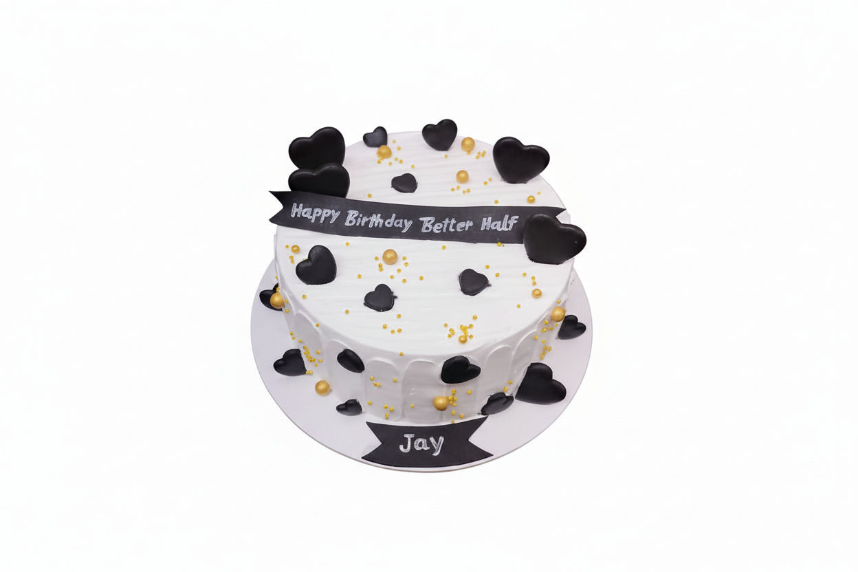 Two-tier birthday cake with black heart decorations and 'Happy Birthday Better Half' message on a white background