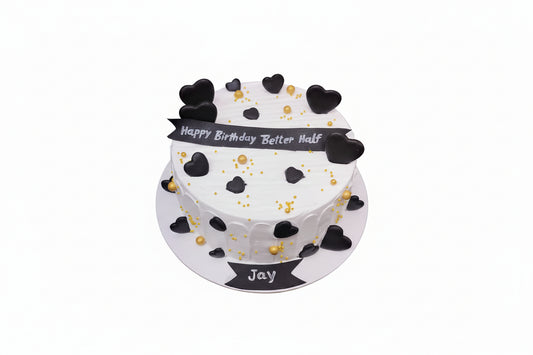 Two-tier birthday cake with black heart decorations and 'Happy Birthday Better Half' message on a white background
