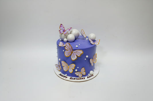 Blue birthday cake with butterfly decorations on a white background