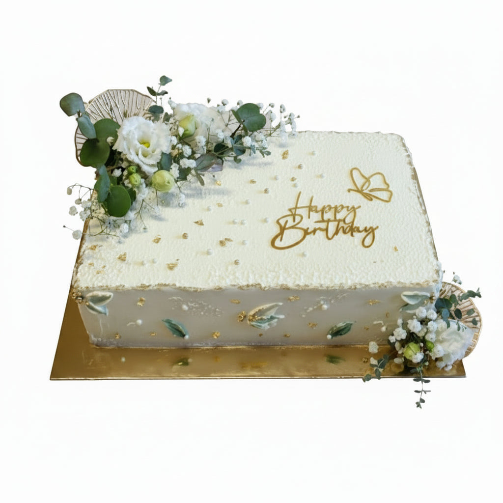 Square birthday cake with floral decorations and 'Happy Birthday' text on a plain background