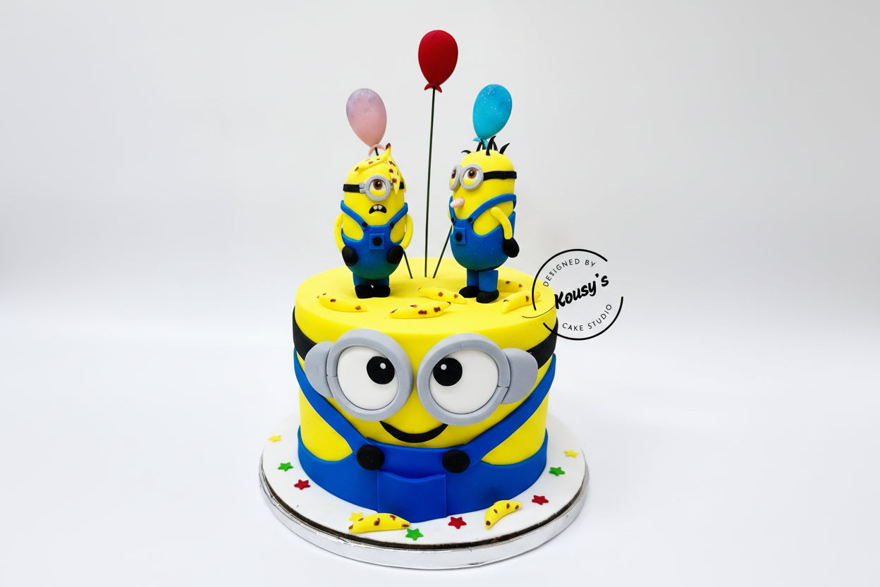 Cake decorated with Minion characters and balloons on a white background