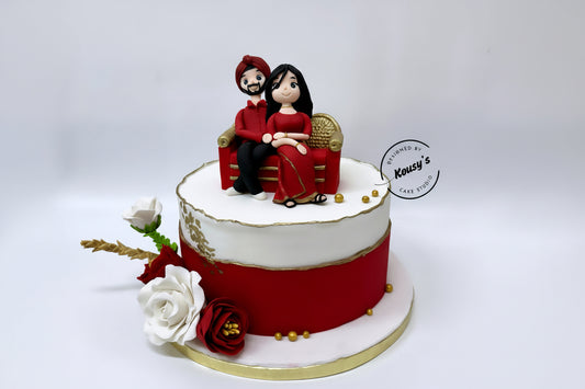 Decorative cake with a couple figurine on top, surrounded by flowers, on a white background.