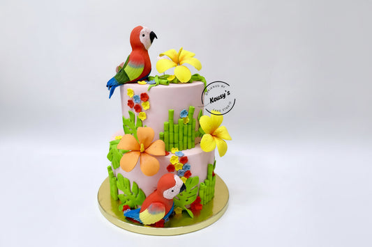 Decorative cake with Scarlet Macaw figures and floral elements on a white background

