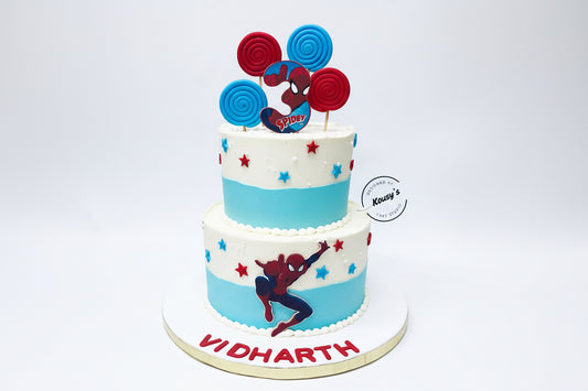 Two-tiered cake with Spider-Man theme and personalized name on a white background