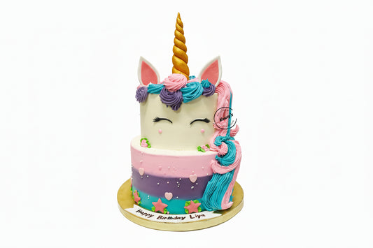 Unicorn-themed birthday cake with colorful frosting and a gold horn on a white background.