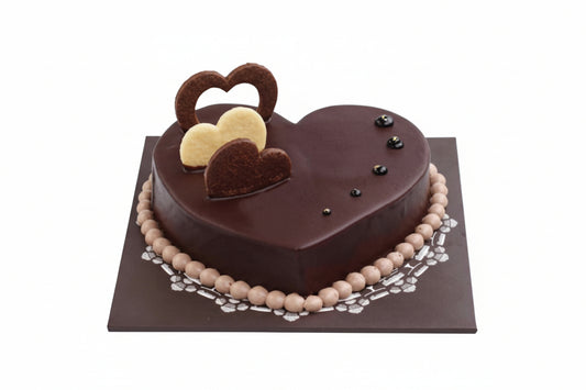 Heart-shaped chocolate cake with decorative elements on a white background