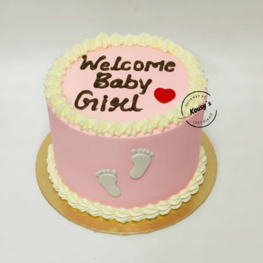 Pink baby shower cake with 'Welcome Baby Girl' text and footprints on a white background